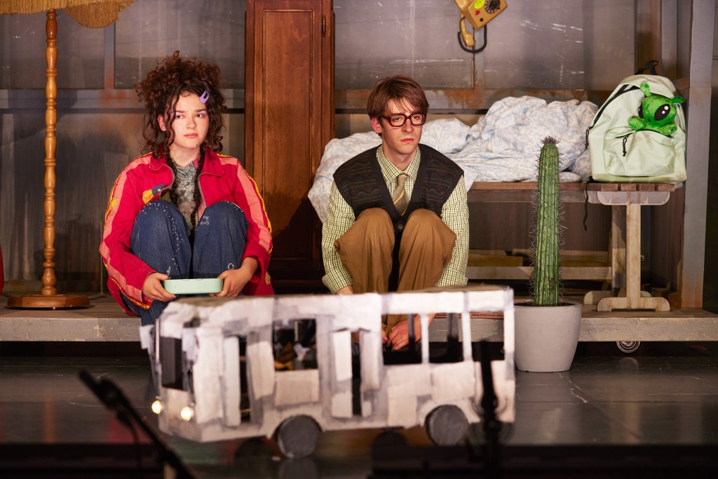 „Tanja Radovanović und Amadeus König in einer ruhigen Bühnenszene aus ‚Kri‘, im Gespräch sitzend.“